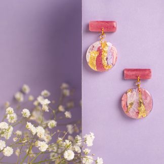 Orecchini artigianali pendenti rosa e oro con base rettangolare e ciondolo rotondo marmorizzato su fondo lilla