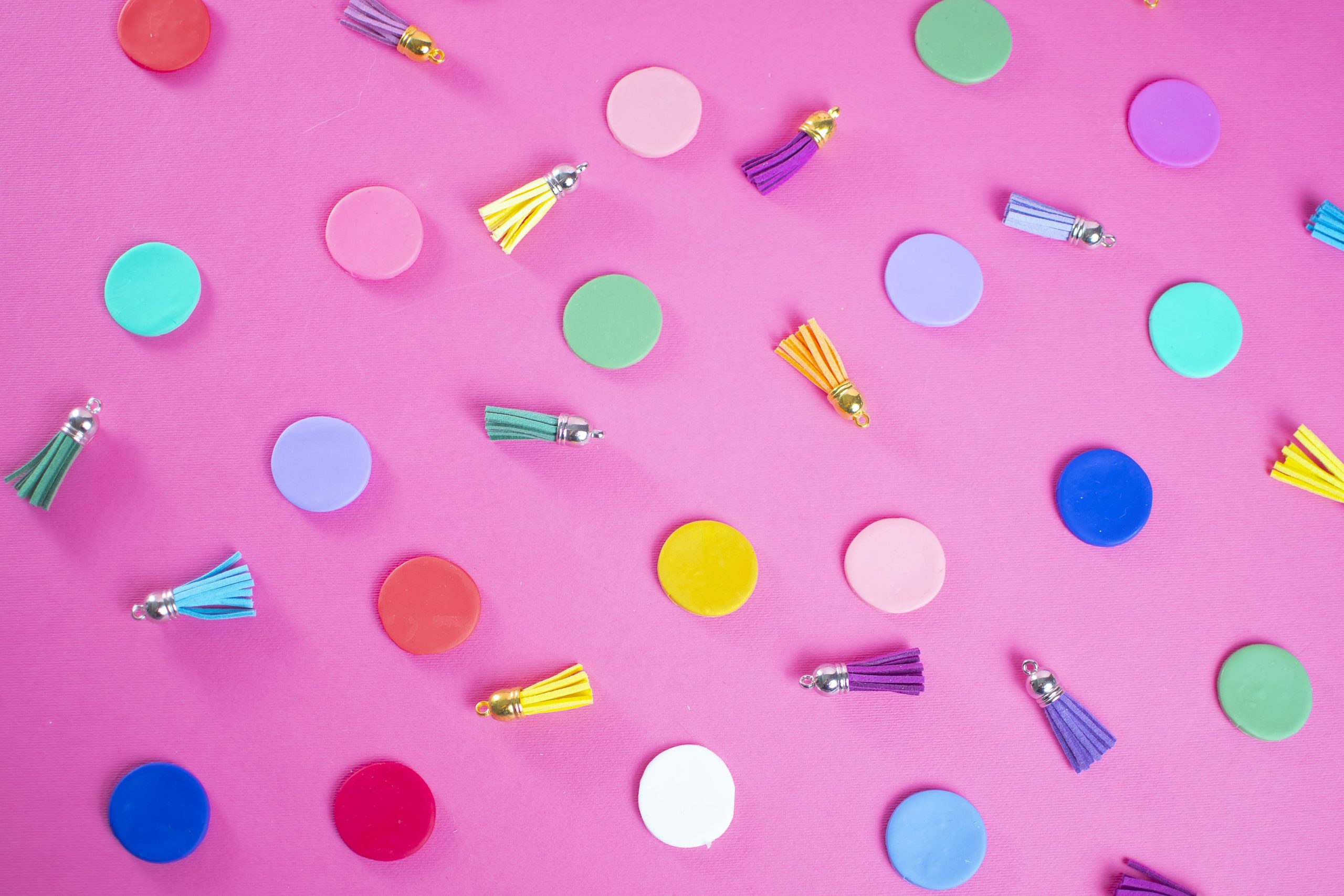 Nappine pendenti in pelle multicolore e dischetti tondi su sfondo rosa